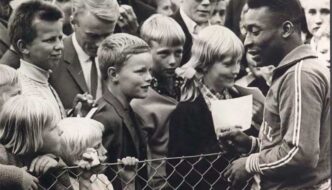 Pelé cercado por crianças durante a Copa de 1958, na Suécia.
