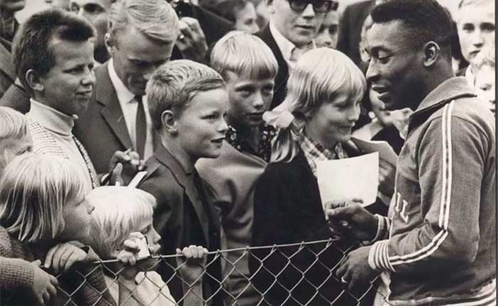 Pelé cercado por crianças durante a Copa de 1958, na Suécia.
